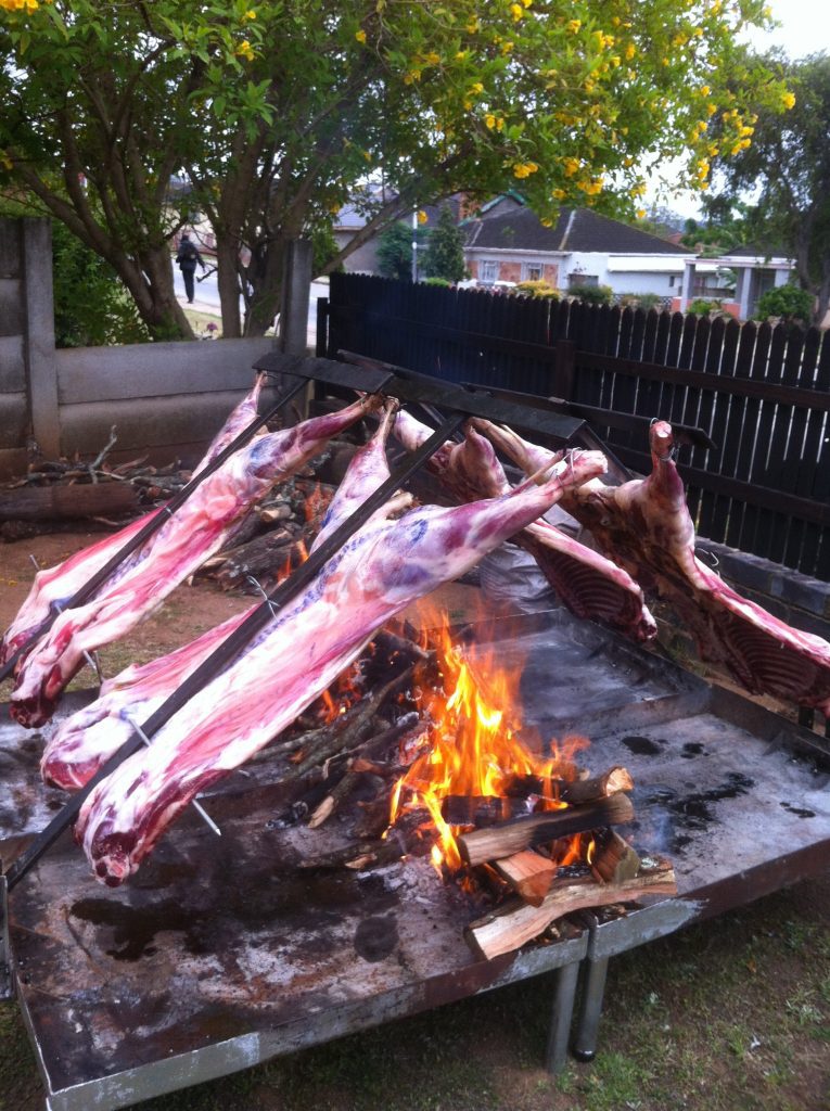 Spitbraai lamb racks set up on-site for a private catering event by Pedros Asado